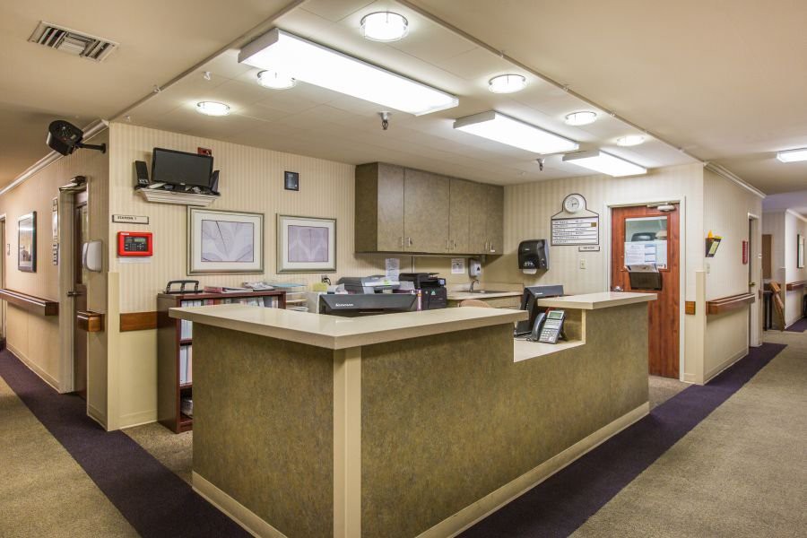 A neatly organized reception desk in an office setting with overhead lighting.