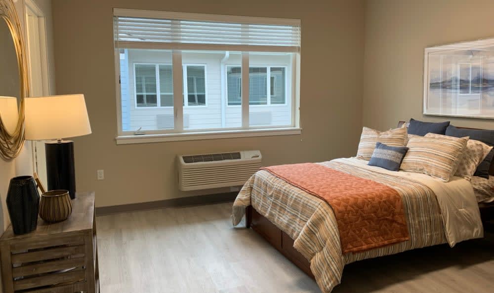 A modern, minimalist bedroom with a single bed and a large window.
