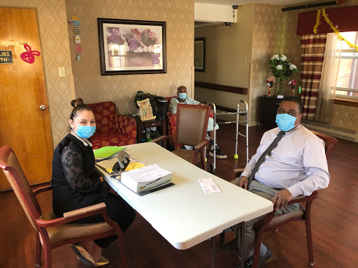 A meeting taking place in a healthcare setting with two individuals wearing face masks.