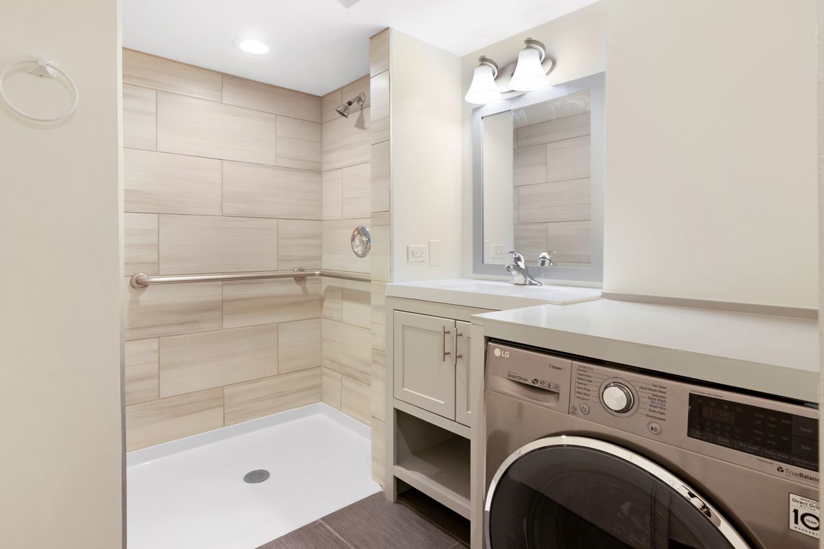 Modern bathroom with a shower and integrated laundry space.
