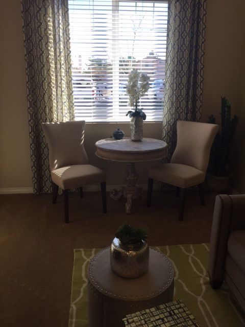 A cozy living room corner with a small round table and two chairs by the window.