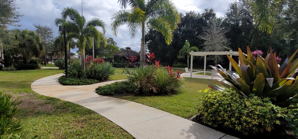 A beautifully landscaped garden with a winding pathway and vibrant tropical plants.