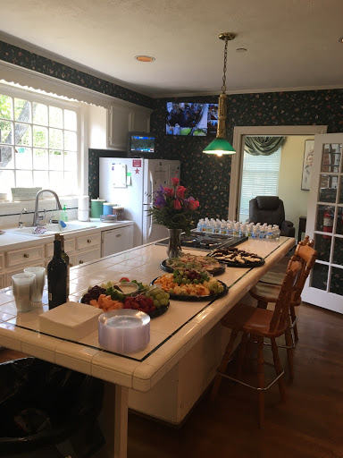 A cozy kitchen setup featuring a dining table with an array of fruits and flowers, perfect for gatherings.