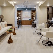 A modern salon interior with a waiting area and styling stations.