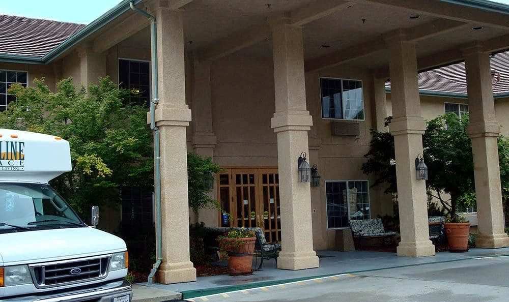 The entrance of a building with large columns and potted plants.