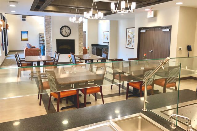 A modern and spacious dining area with stylish seating and elegant chandeliers.