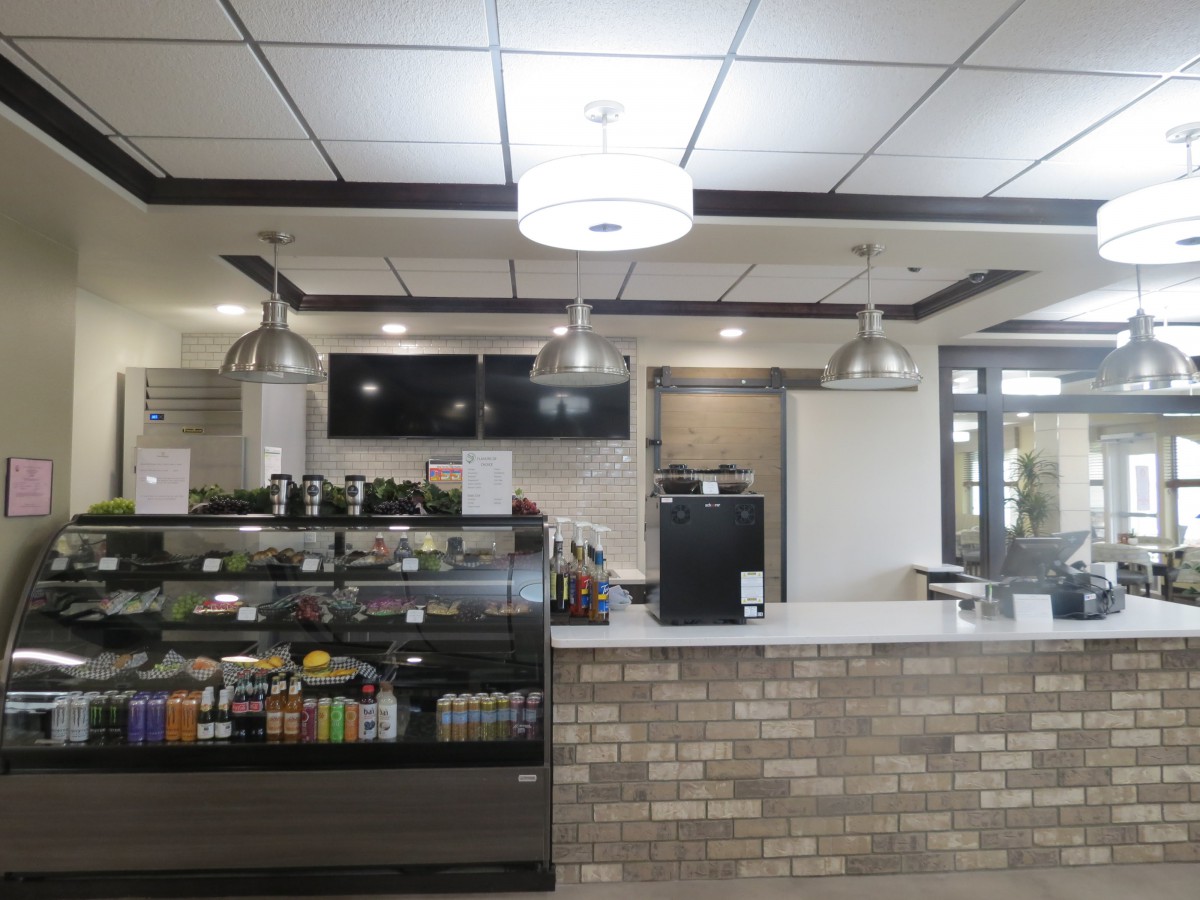 A modern cafe counter with a display case and overhead lighting.