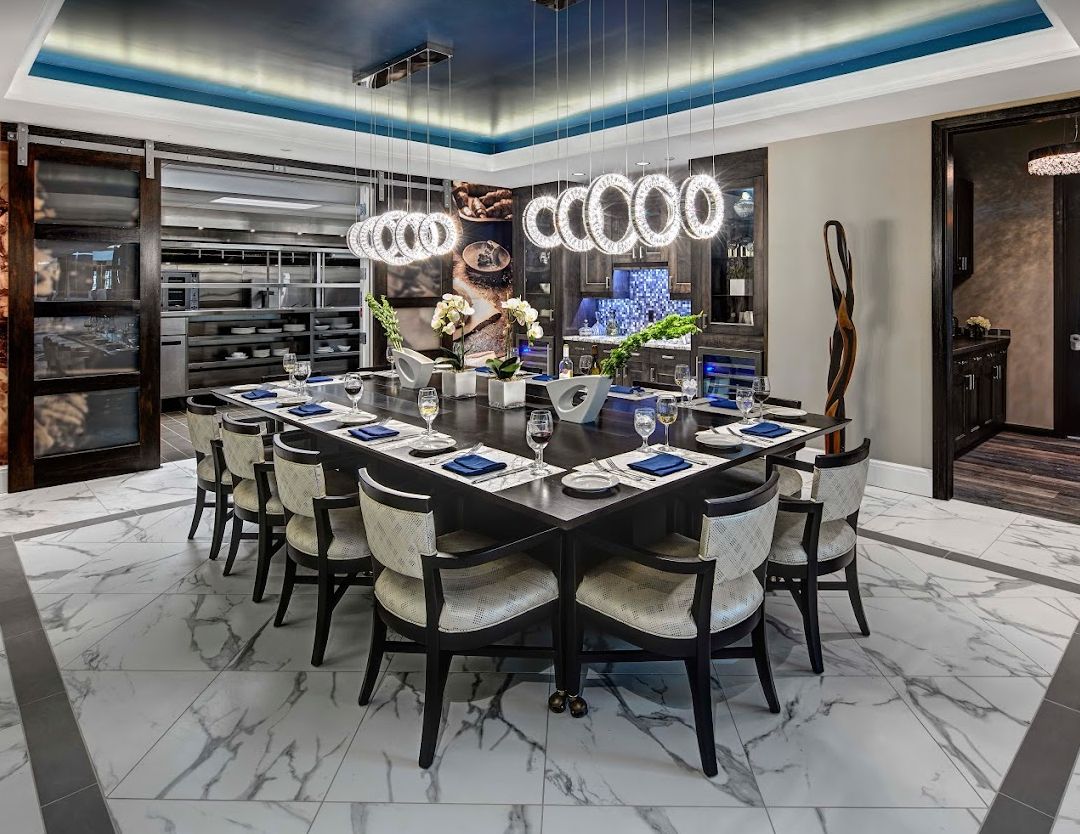 A luxurious and modern dining room with elegant furniture and chandelier lighting.