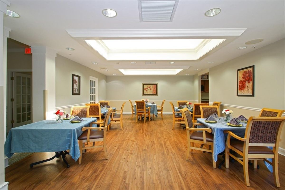 A well-lit dining area with neatly arranged tables and chairs.