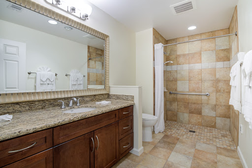 A modern bathroom featuring a stylish vanity, spacious mirror, and a tiled shower area.