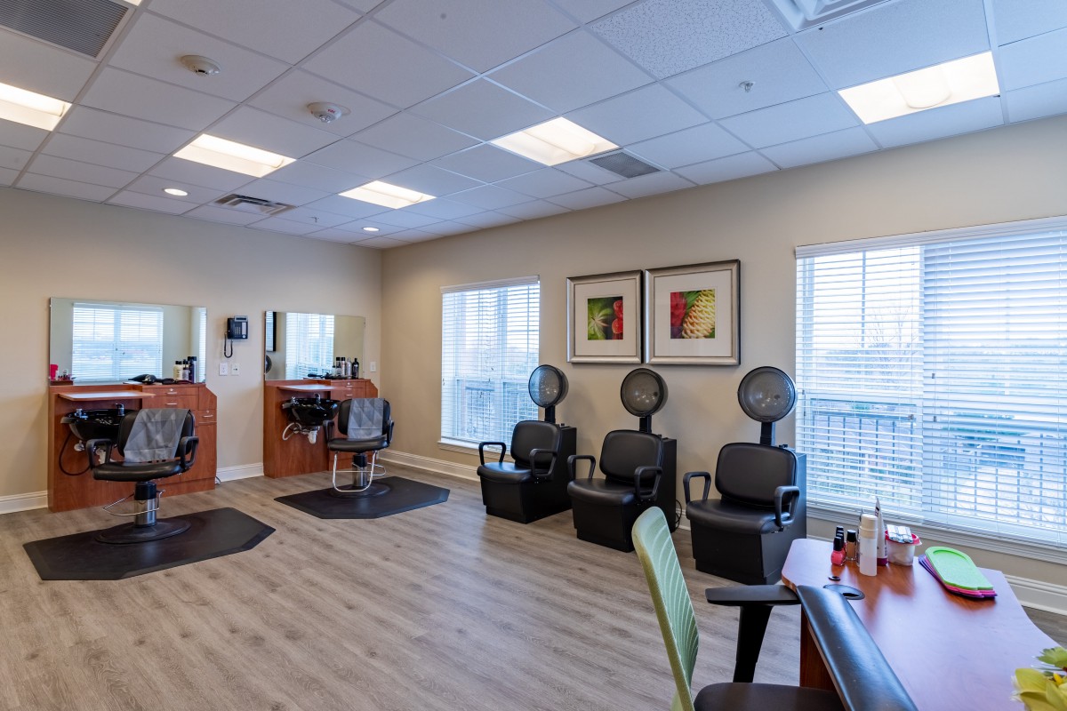 A tidy hair salon featuring styling chairs and hair drying stations.