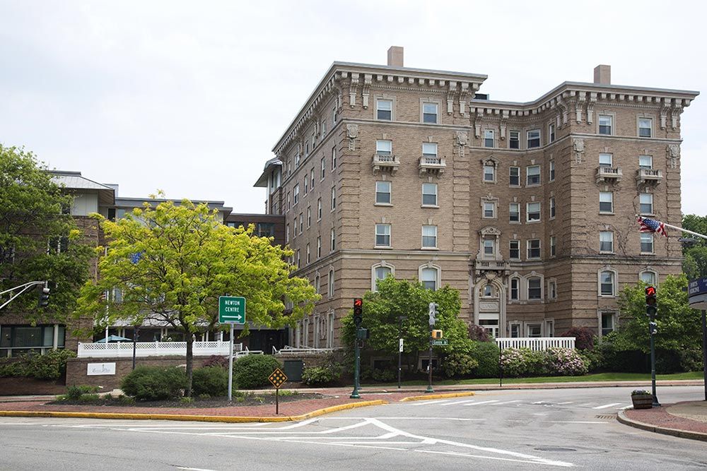 A historic urban building with trees lining the street corner.
