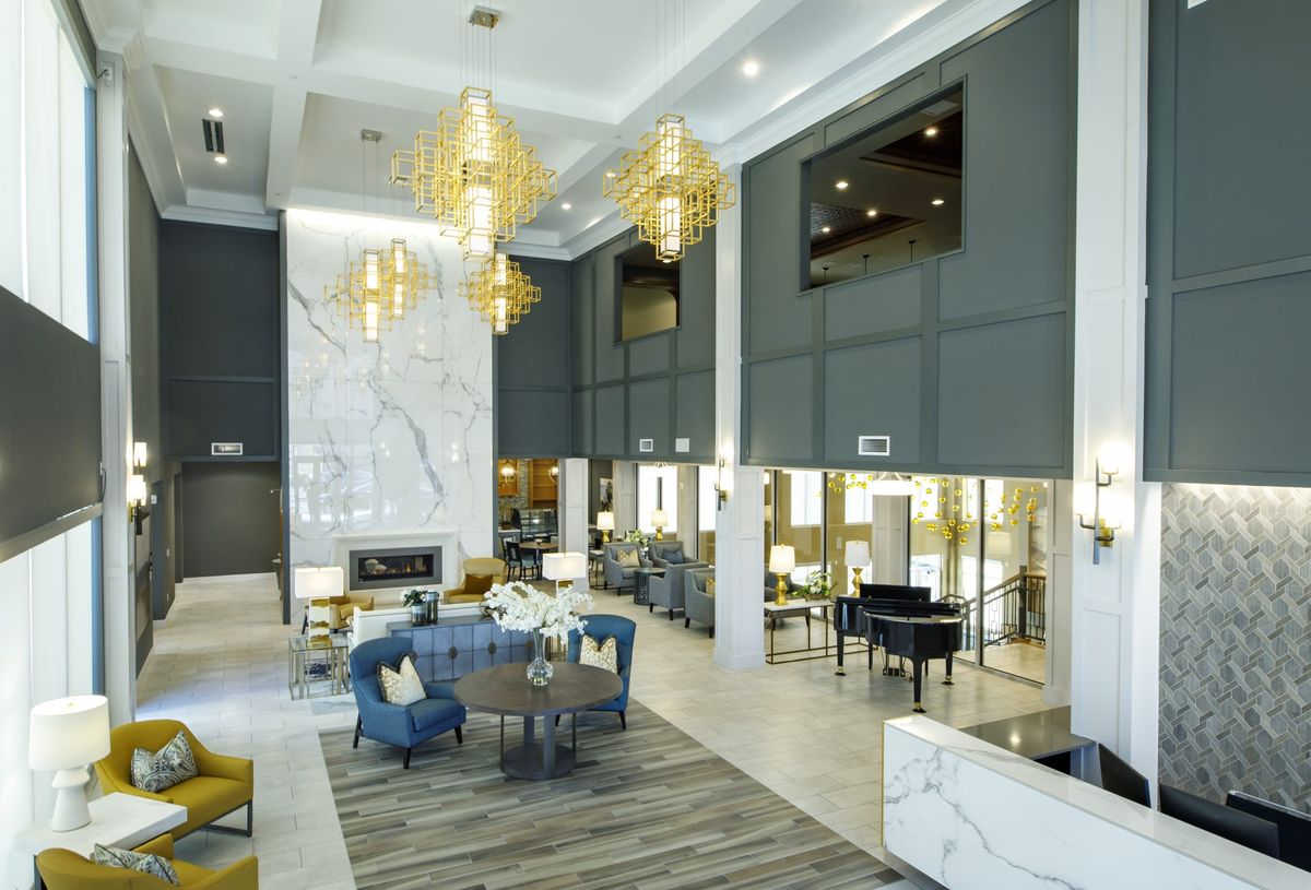A luxurious hotel lobby featuring elegant chandeliers, a stylish seating area, and modern interior decor.