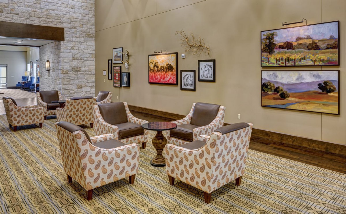 A cozy lobby seating area featuring patterned chairs and wall art.