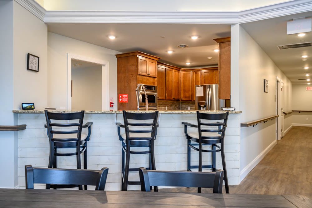 A modern kitchen with wooden cabinets and bar seating.