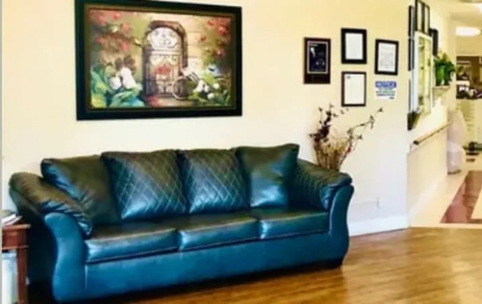 A cozy living room featuring a green sofa, artwork on the wall, and decorative elements.
