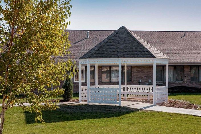A house with a white gazebo in the front yard.