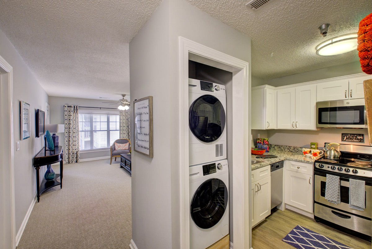 Modern apartment interior with a stackable washer and dryer beside the kitchen.