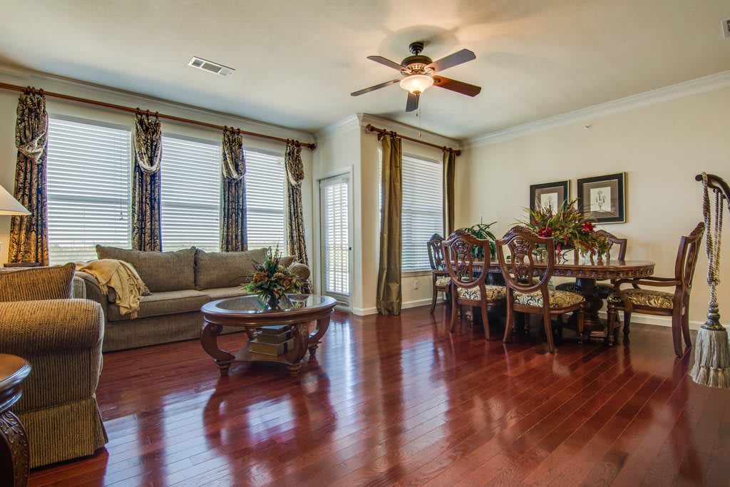 Spacious living and dining area with hardwood floors and a ceiling fan.