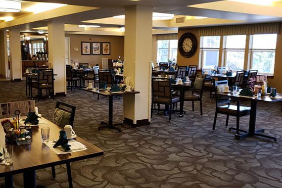 An empty restaurant dining area with neatly arranged tables and chairs.