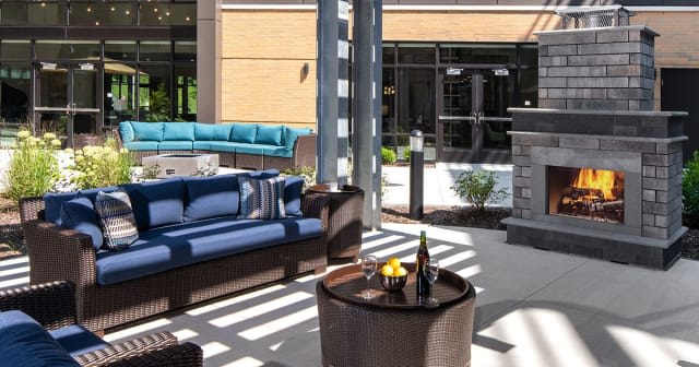 A stylish outdoor patio with comfortable seating and a table set for drinks.
