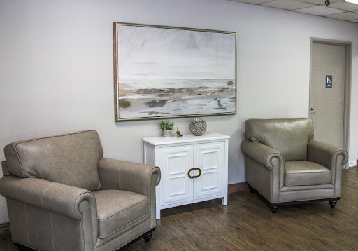 A cozy and modern living room setup featuring neutral-toned furniture and a serene artwork.