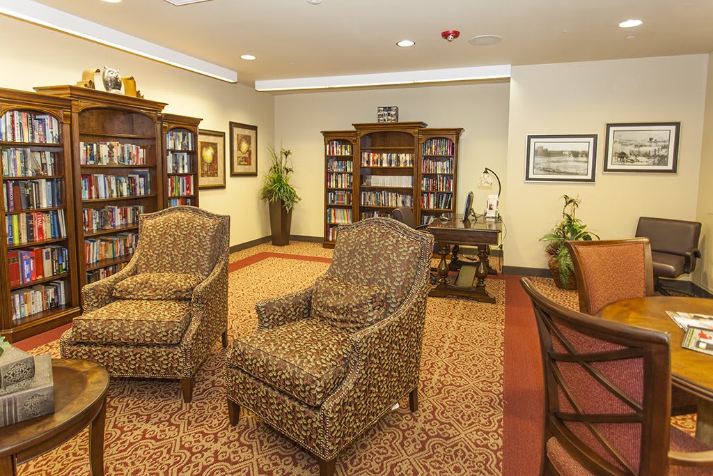 Cozy library room with bookshelves and comfortable armchairs.