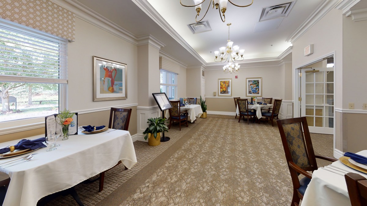 A well-decorated dining area with elegant chandeliers and art on the walls.