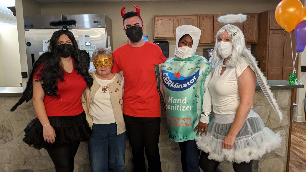 A group of people wearing costumes and masks, celebrating indoors.