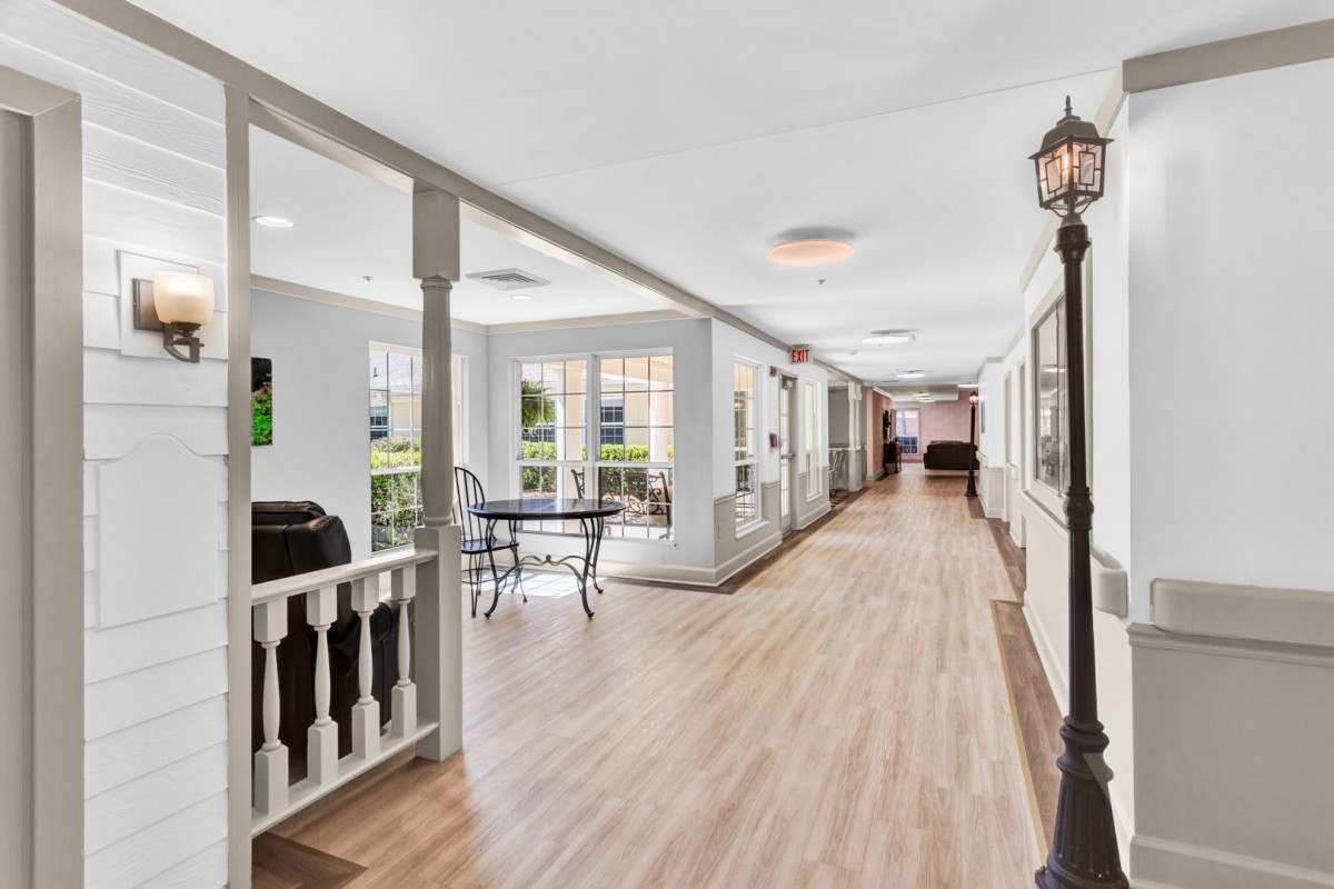 A bright hallway with wooden flooring and natural light streaming through the windows.