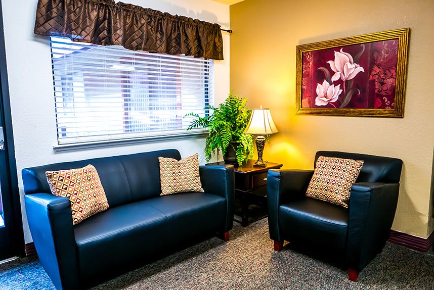 A cozy living room with a sofa, armchair, and warm lighting.
