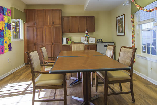 A small conference room with a meeting table and chairs, surrounded by wooden cabinetry.