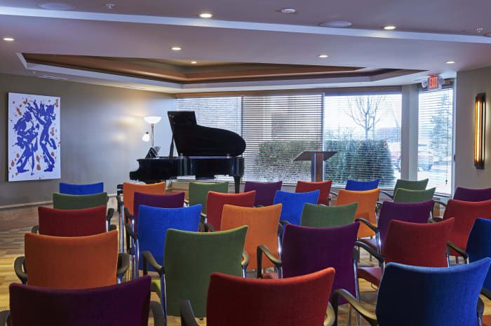 A colorful auditorium with a piano ready for a performance.