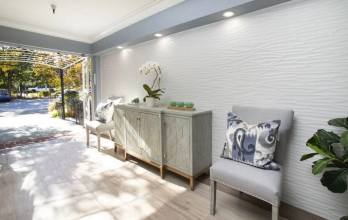 A modern living space with natural light, featuring a sideboard and stylish chairs.