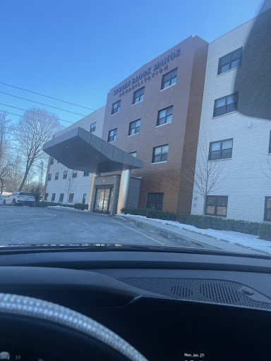 A view of a hotel building with a sloped roof, set against a clear winter sky.