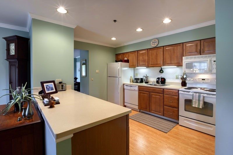 A modern kitchen with wooden cabinets and stainless steel appliances.
