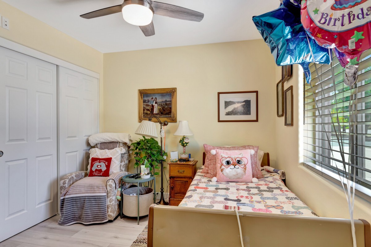 A cozy bedroom with a bed, armchair, and decorative elements on the walls.