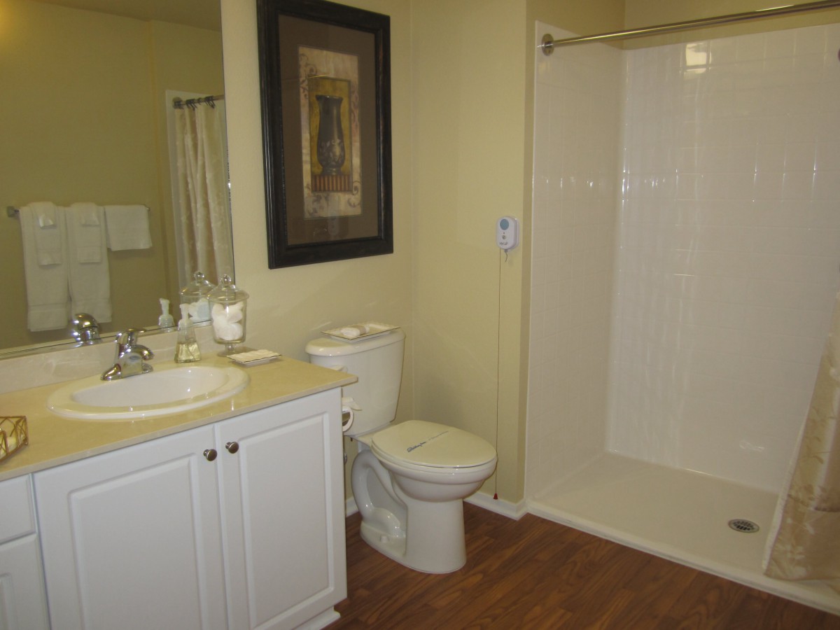 A clean and modern bathroom with a shower, sink, and toilet.