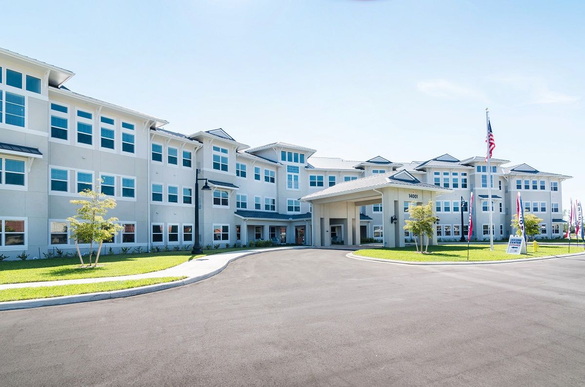 A modern multi-story building with numerous windows and a welcoming entrance.