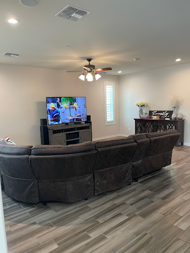 A cozy living room featuring a modern sofa arrangement and a wall-mounted television.