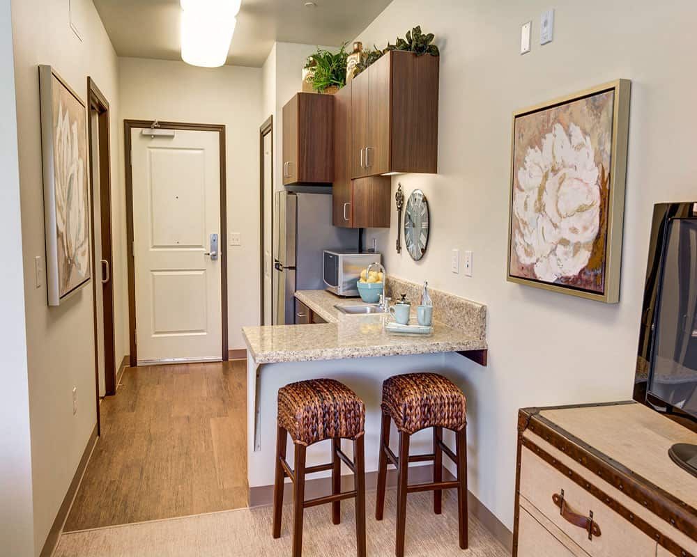 A cozy apartment kitchen with bar stools and modern decor.
