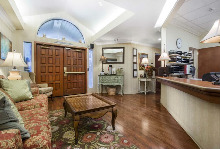 A cozy waiting room featuring wooden furniture and decorative items.