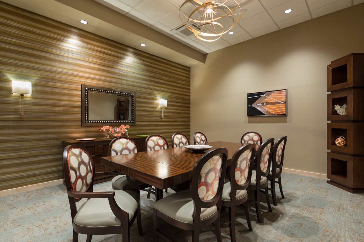 A modern conference room with elegant decor and a central meeting table surrounded by chairs.