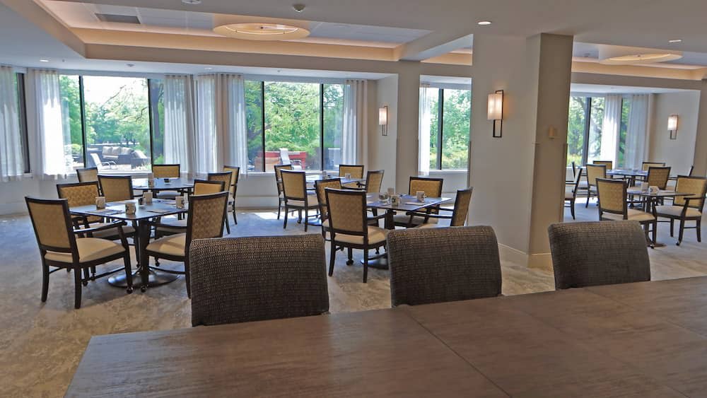 A well-lit dining area with multiple tables and chairs, showcasing a modern interior.