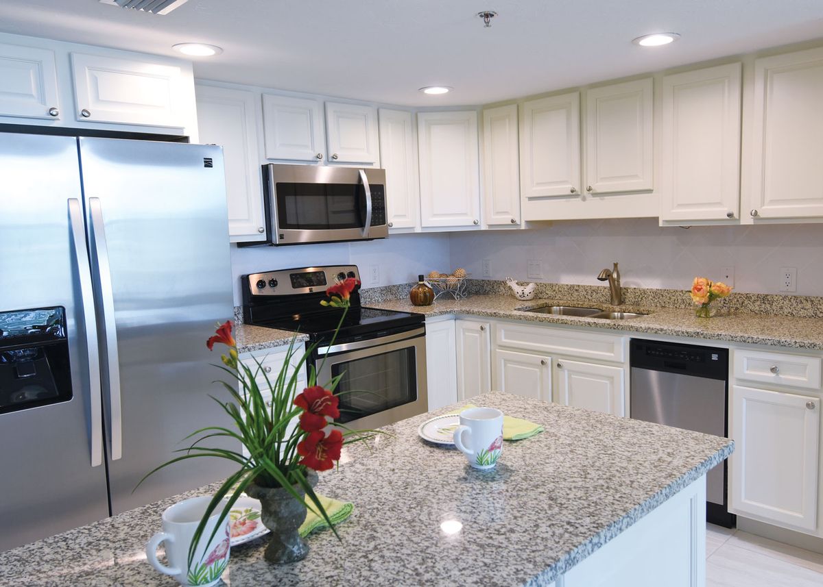 A modern kitchen with granite countertops and stainless steel appliances.