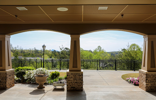 A serene view from a covered porch, showcasing lush greenery and a distant landscape.