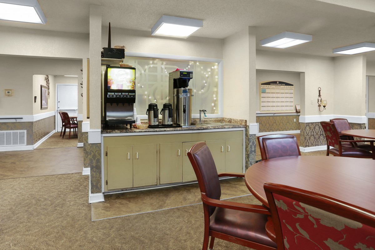 A cozy indoor cafe area with a coffee station and comfortable seating.