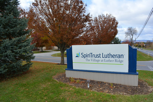 Entrance sign for SpiritTrust Lutheran, surrounded by autumn foliage.