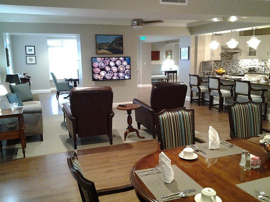 A spacious living and dining area featuring a television, comfortable seating, and an open kitchen.