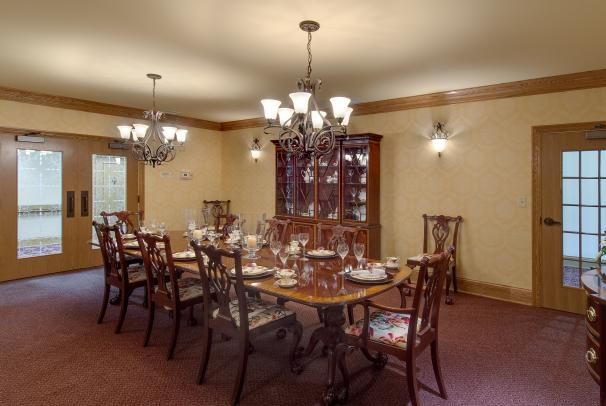 A traditional dining room with an elegant table setting and chandelier lighting.